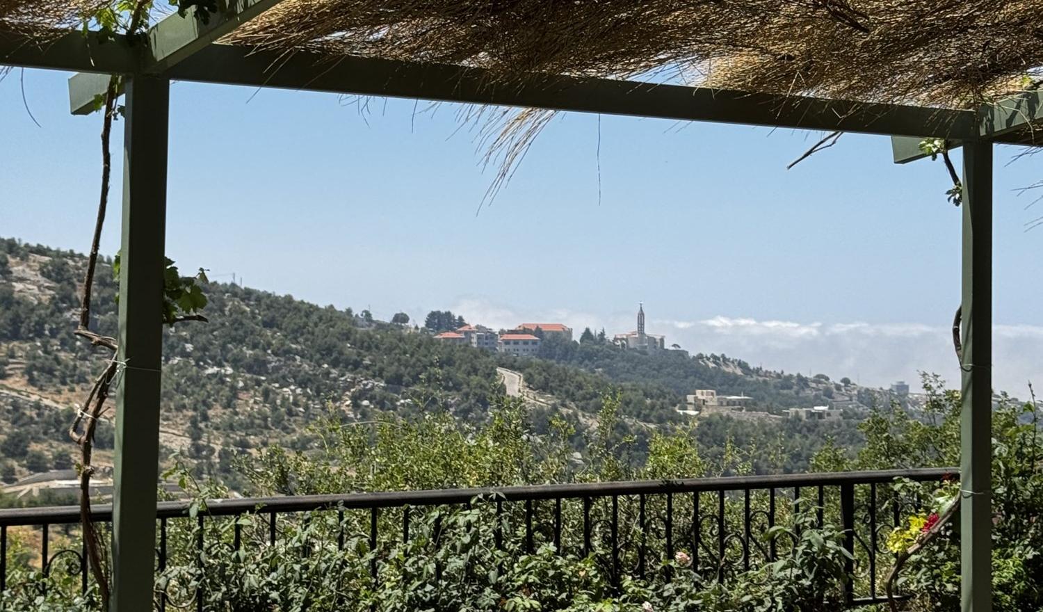 From the pergola at Ardouna: the olive hills and the monastery of Saint Charbel at Annaya across the valley, with clouds over the coast